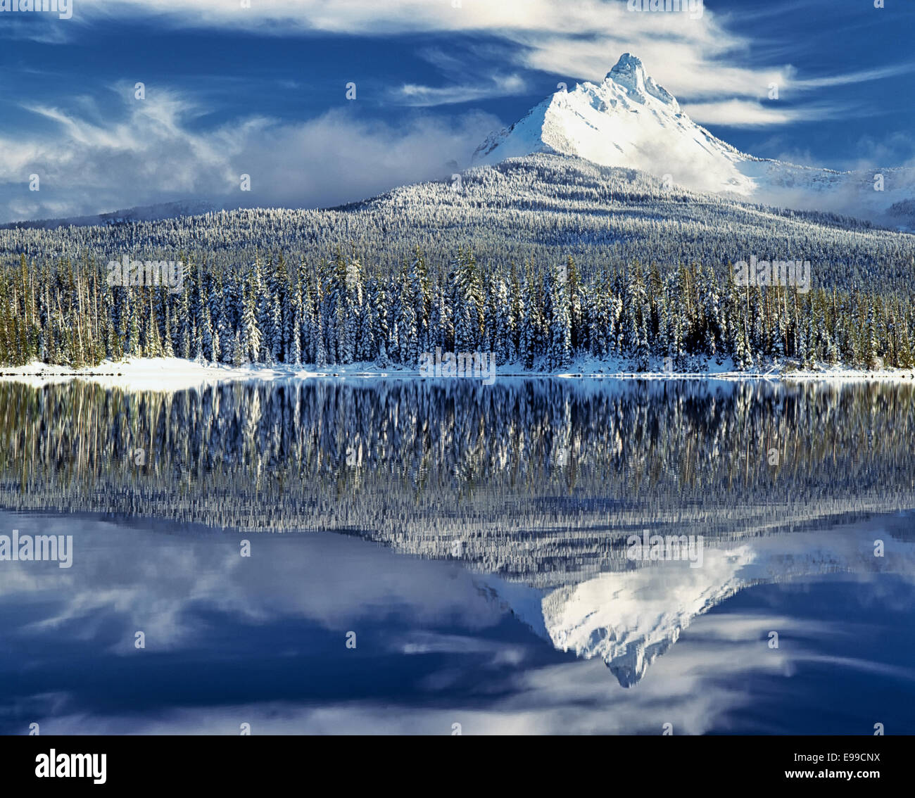 Zentral-Oregon Mt Washington ergibt sich aus den Wolken, den ersten Winter Schneefall und Abend Reflexion in Big Lake zu offenbaren. Stockfoto