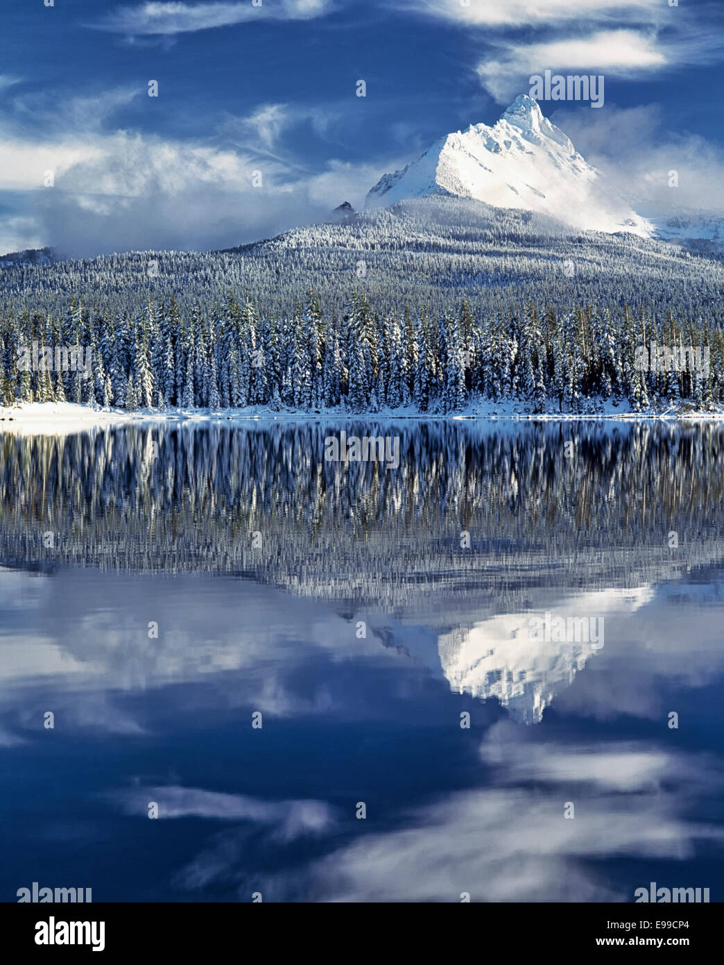 Zentral-Oregon Mt Washington ergibt sich aus den Wolken, den ersten Winter Schneefall und Abend Reflexion in Big Lake zu offenbaren. Stockfoto