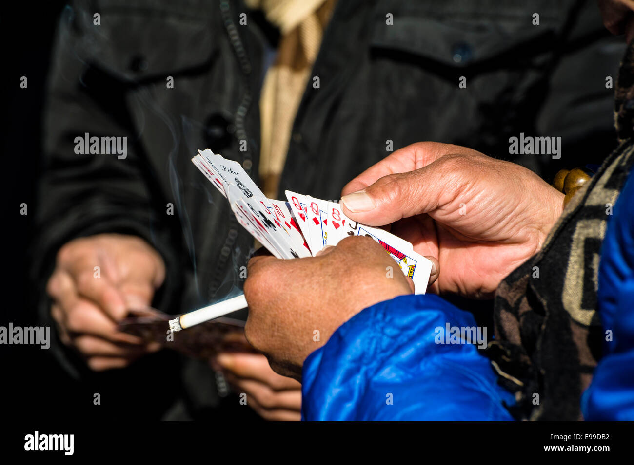 Der Mann mit einer Zigarette Karte spielen Stockfoto