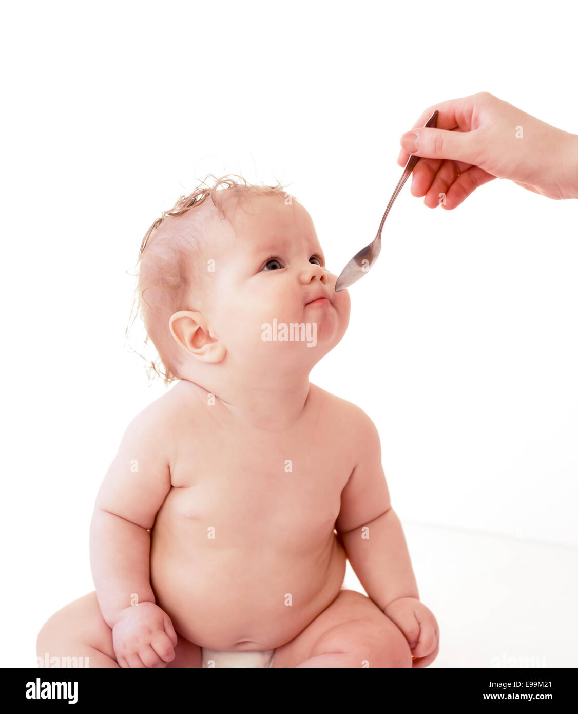 Baby mit Löffel füttern oder Medikamenteneinnahme Stockfoto