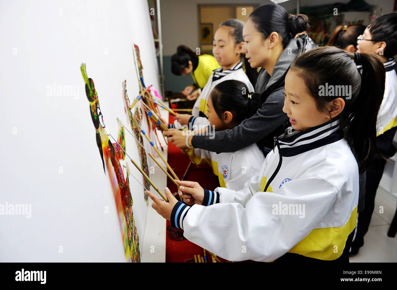 (141023)--TANGSHAN, 23. Oktober 2014 (Xinhua)--die Studierenden lernen, Schattenfiguren in der Luanxian Grafschaft, Nord-China Provinz Hebei, 23. Oktober 2014 spielen. Schattenspiel oder Schattentheater, ist eine alte Form des Erzählens und Unterhaltung mit undurchsichtig, oft artikuliert Figuren vor einem beleuchteten Kulisse um die Illusion der bewegten Bilder zu schaffen. (Xinhua/Zhu Xudong) (Ry) Stockfoto