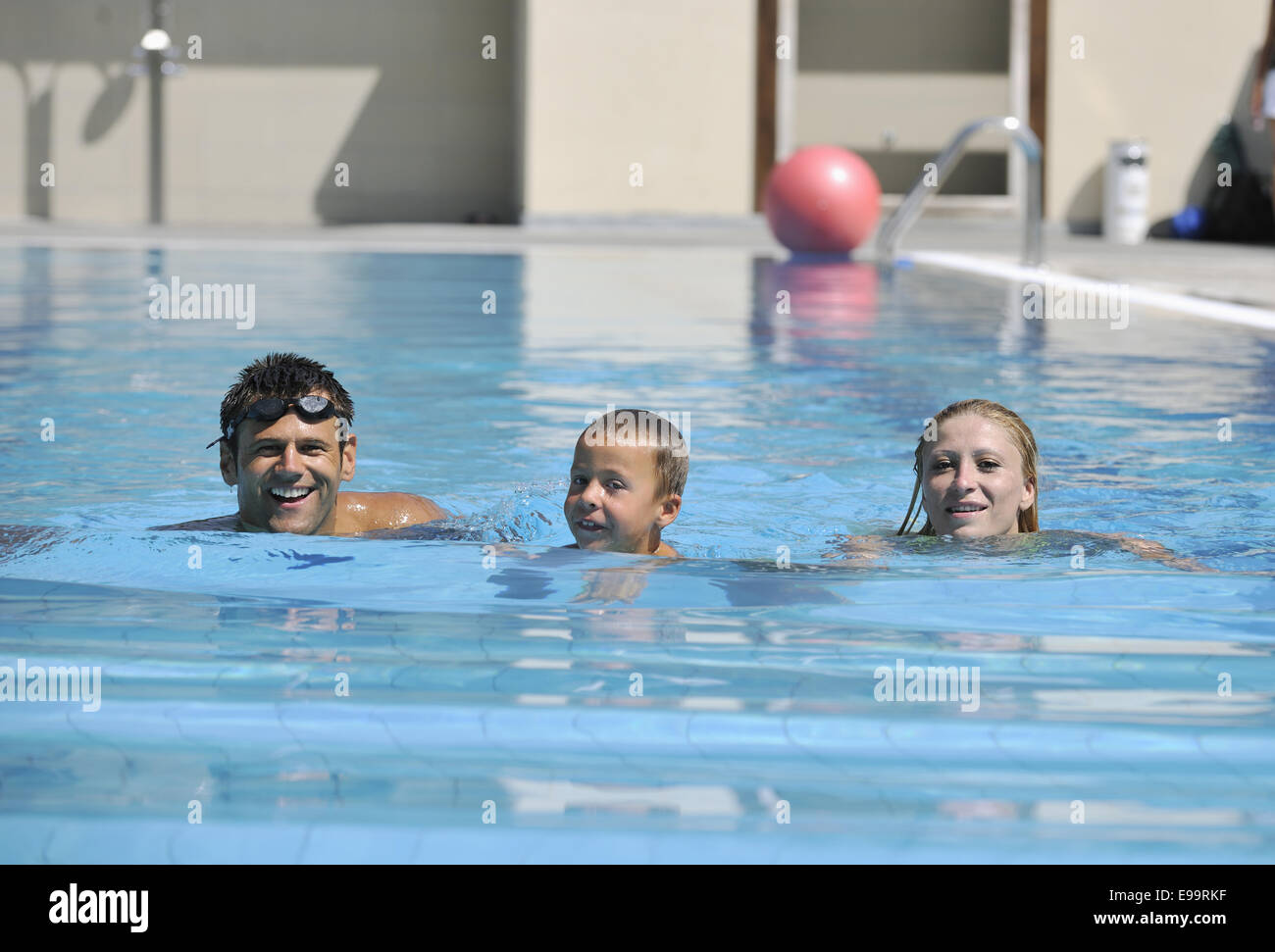 glückliche junge Familie viel Spaß im Schwimmbad Stockfotografie Alamy