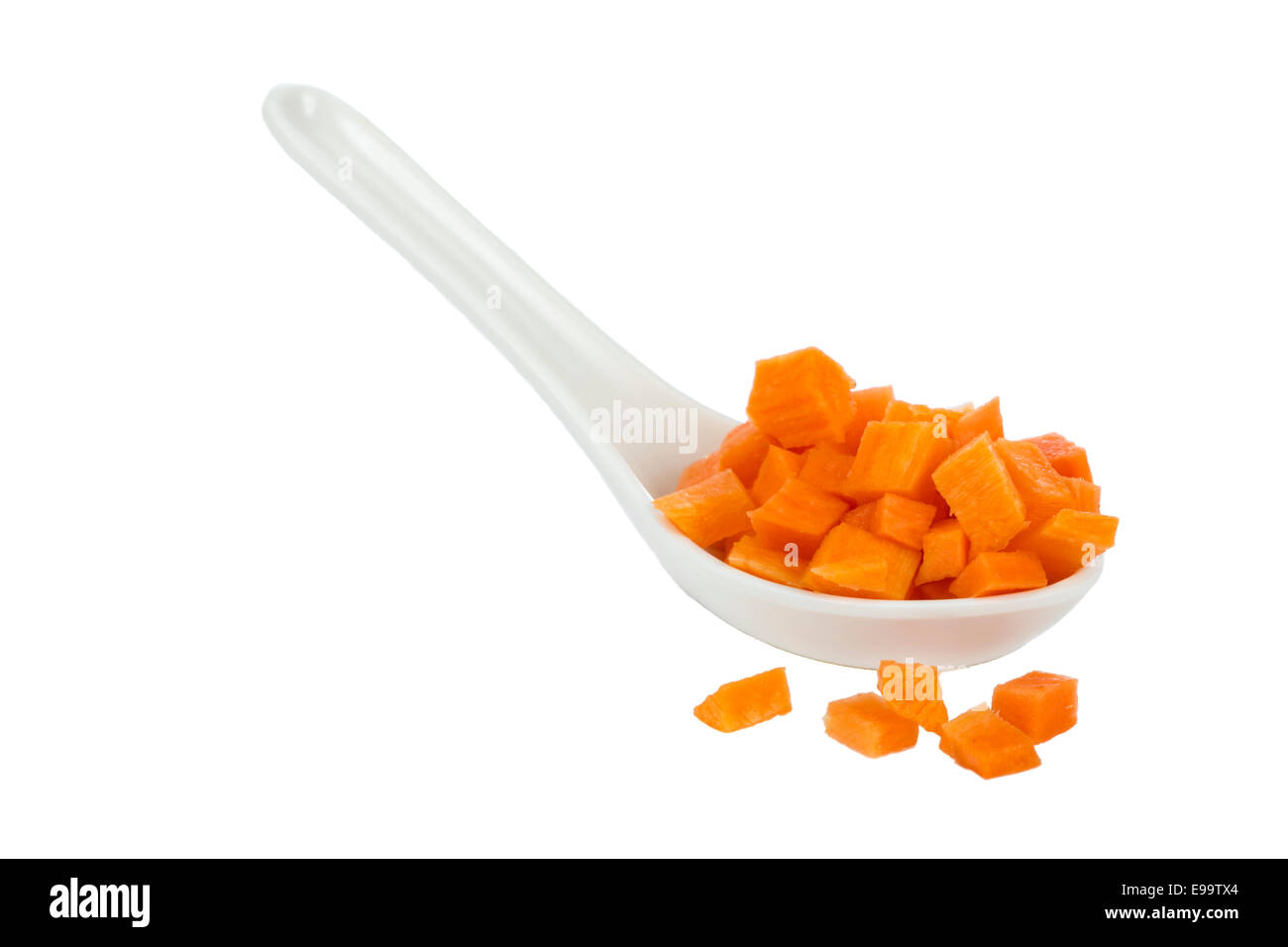 Gehackte rohe Karotten in einem weißen Löffel isoliert auf weißem Hintergrund. Stockfoto