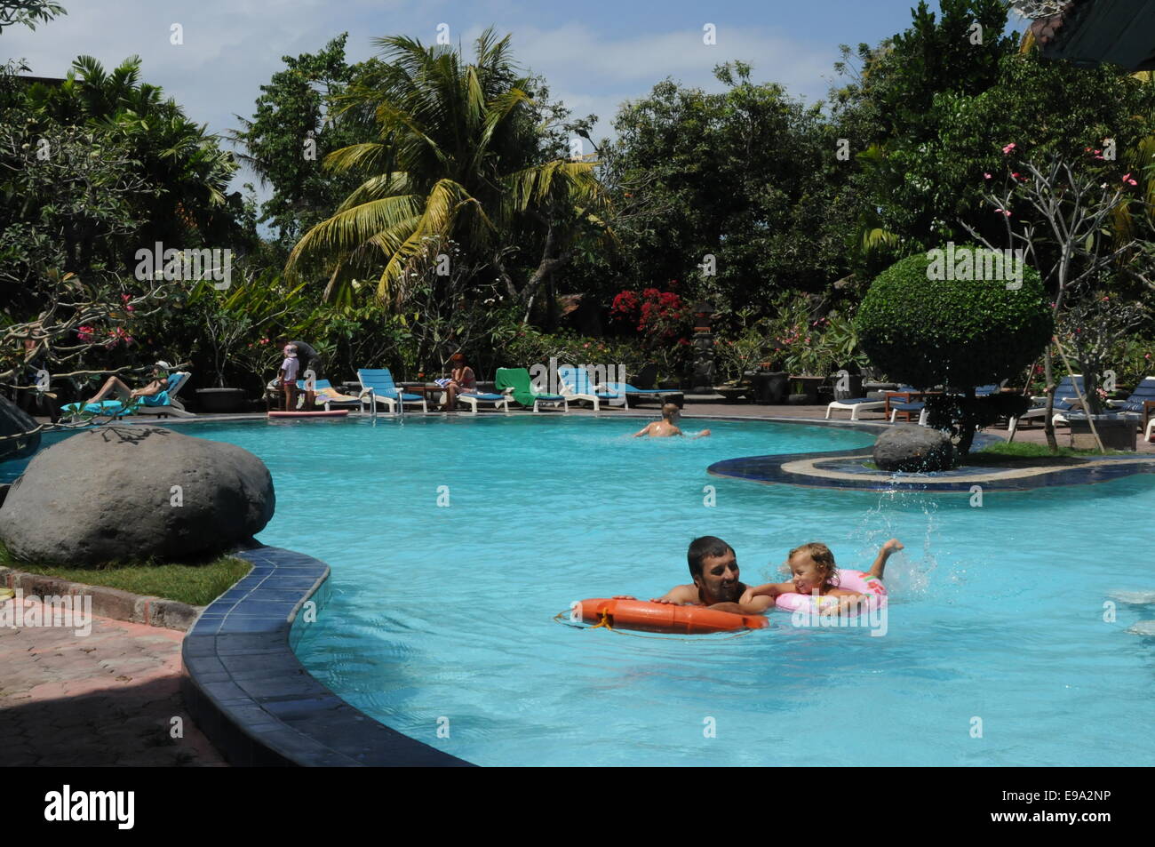 Matahari Bungalow Hotel-Pool in Kuta Legian Street. Bali. Ein Vater badet mit ihrer Tochter. Swimmingpool des Hotels. Kuta ist eine Küste Stockfoto