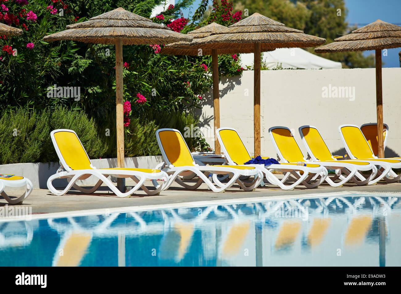 Leere Liegestühle rund um Schwimmbad Stockfoto