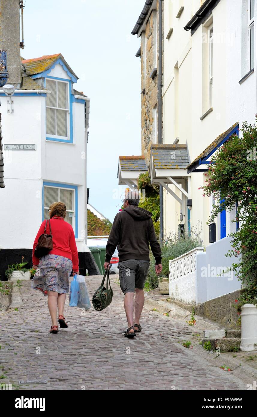 Ein Mann und eine Frau Tragetaschen zu Fuß Liebe hinaufgeschossen St Ives Cornwall England uk Stockfoto