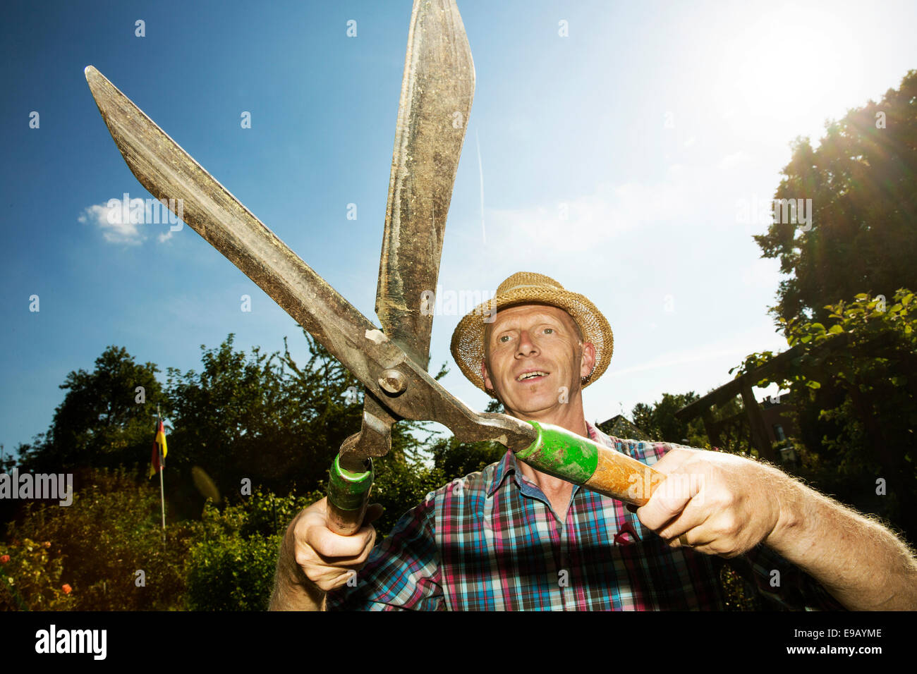 Gärtner, Garten des Grundstückes Halter tragen einen Strohhut und Heckenschere, Köln, Nordrhein-Westfalen, Deutschland Stockfoto