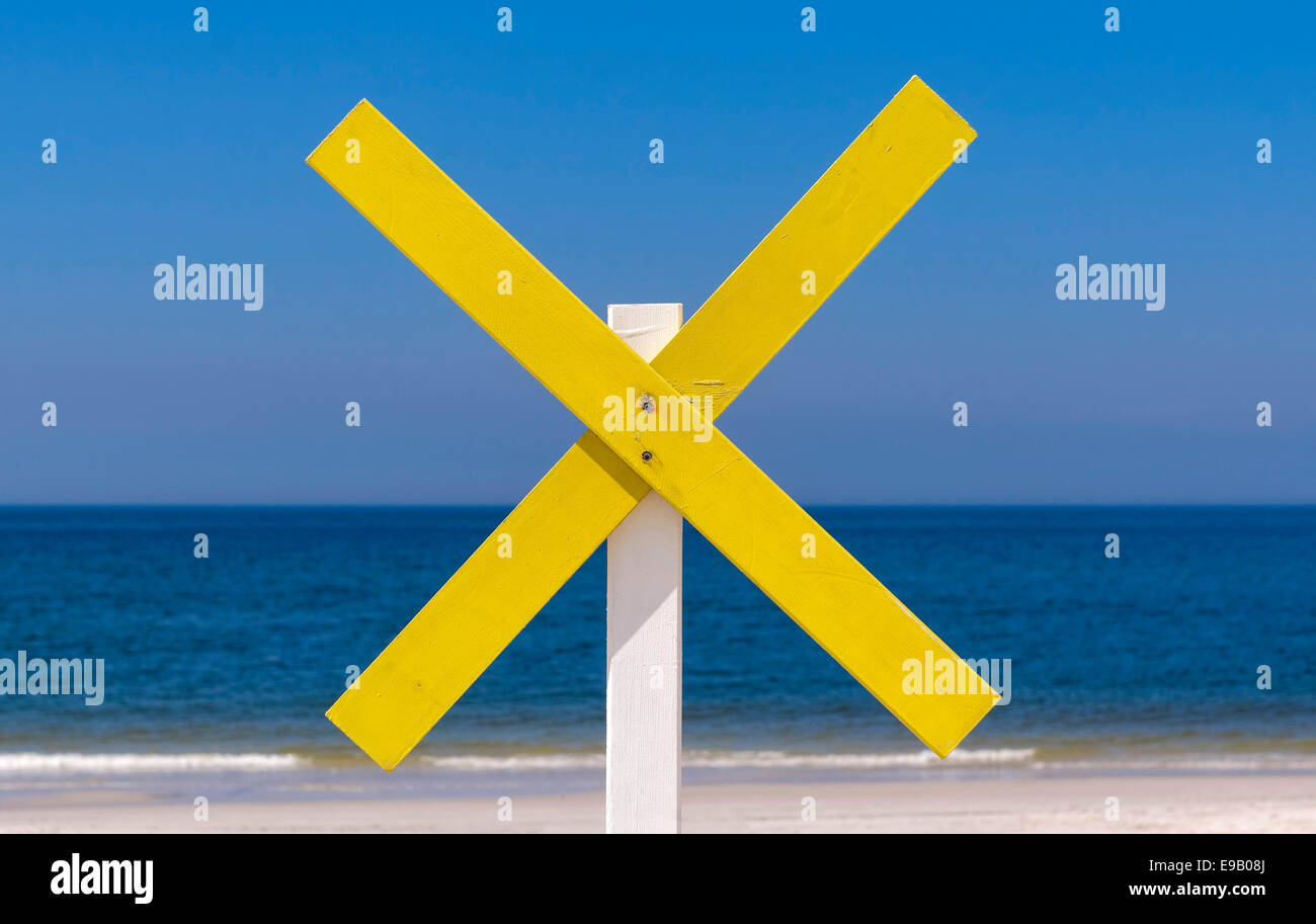 Eine gelbe Holzkreuz markiert eine Untiefe nahe der Küste am Strand, in der Nähe von Kampen