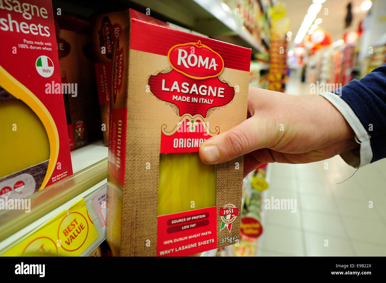 männlichen Roma Lasagne aus dem Regal nehmen (Nachrichtensendung)(Model Released) Stockfoto