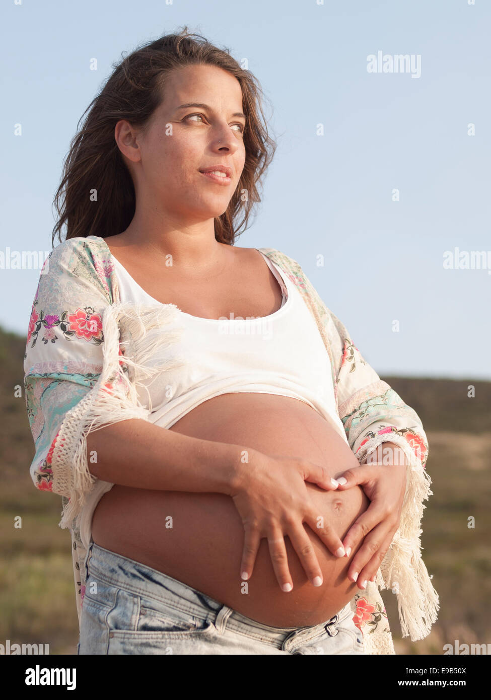 Schwangere Frau am Strand im freien Stockfoto