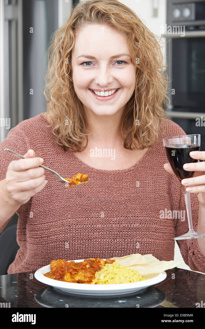 Frau zum Mitnehmen Curry Essen und trinken Wein Stockfoto