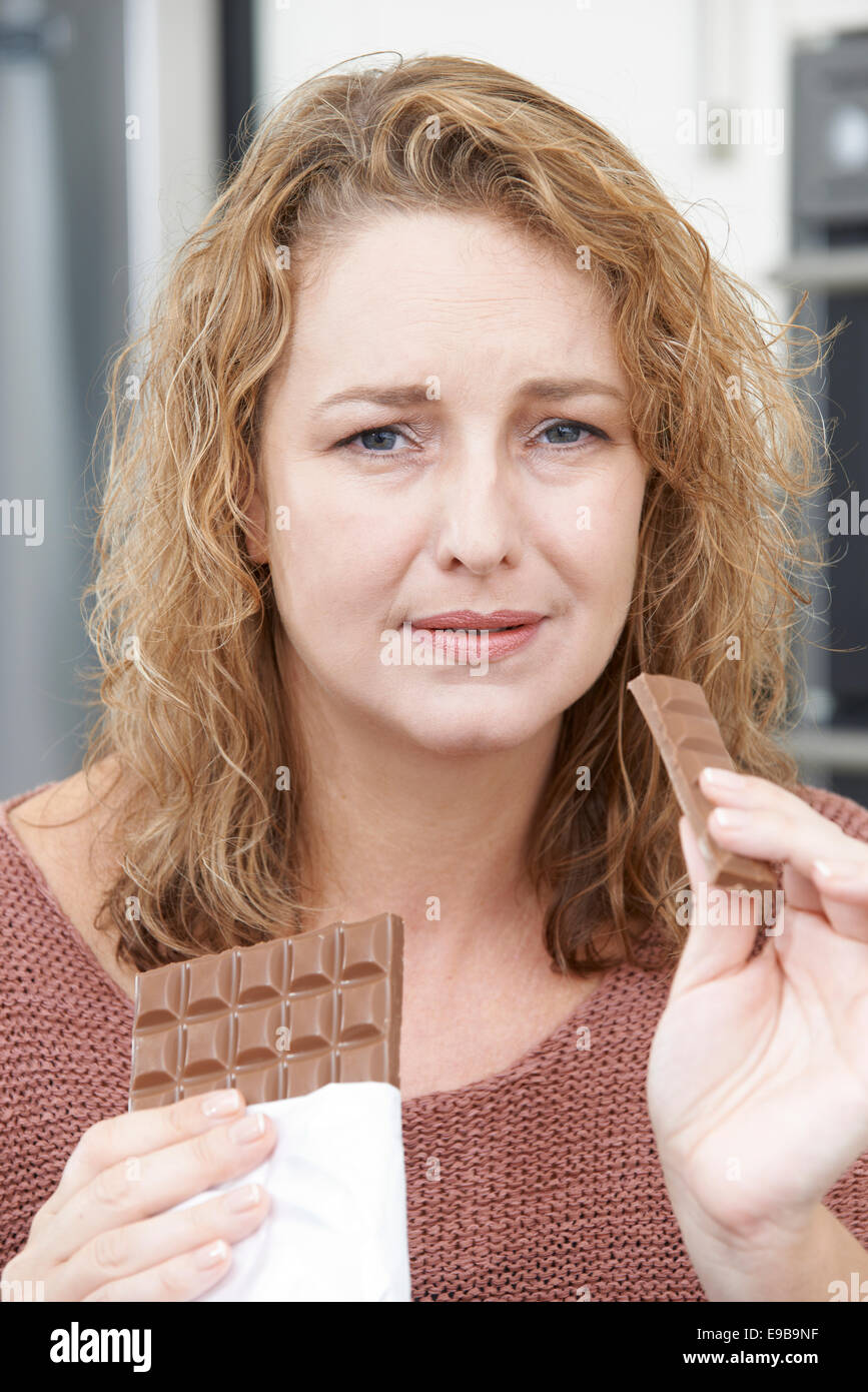 Guilty Frau Diät Schokolade zu Hause essen Stockfoto
