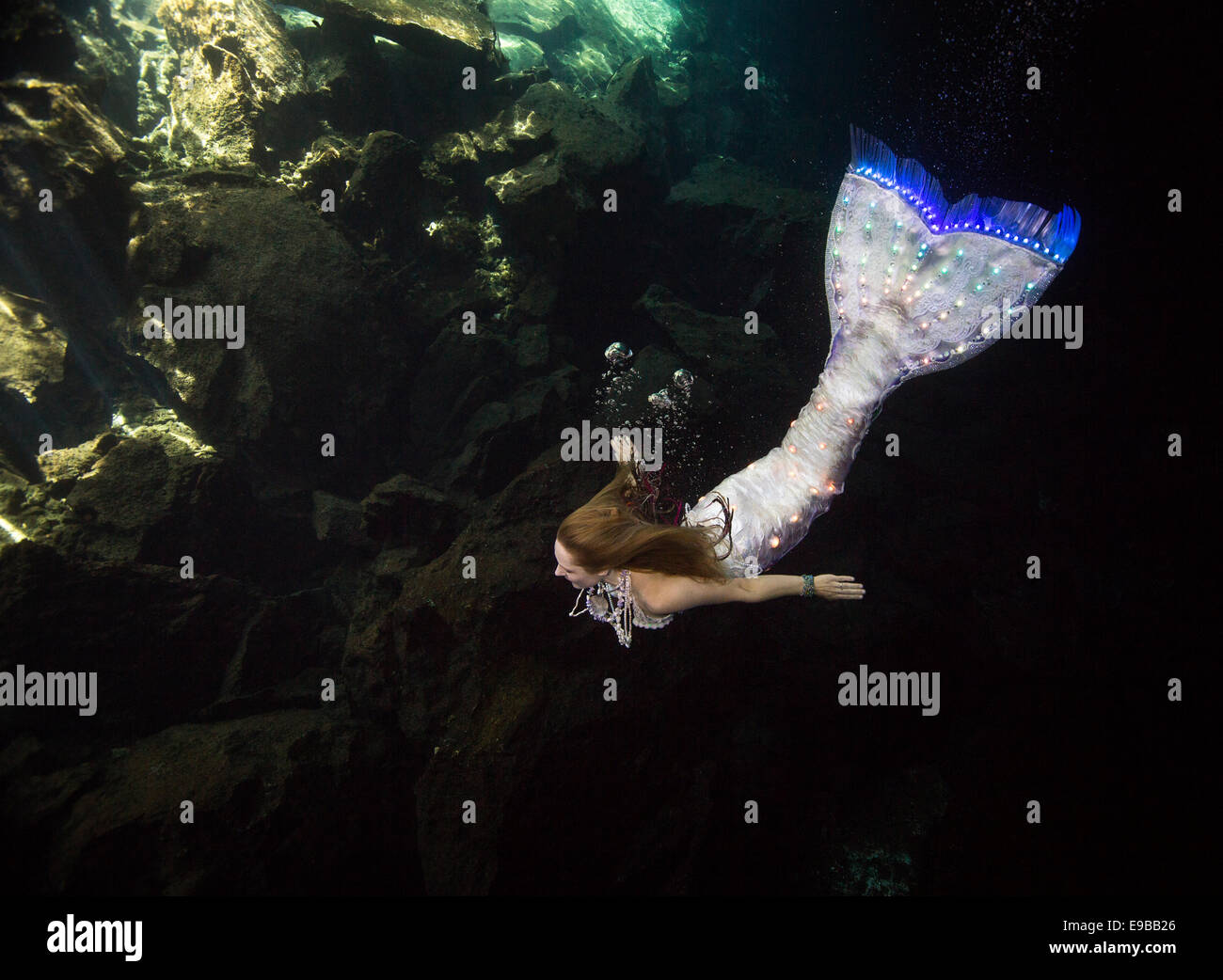 Meerjungfrau mit einem leuchtenden Schweif, Schwimmen in den Gewässern der Halbinsel Yucatan, KuKulKan Cenote, QRoo, Mexiko Stockfoto