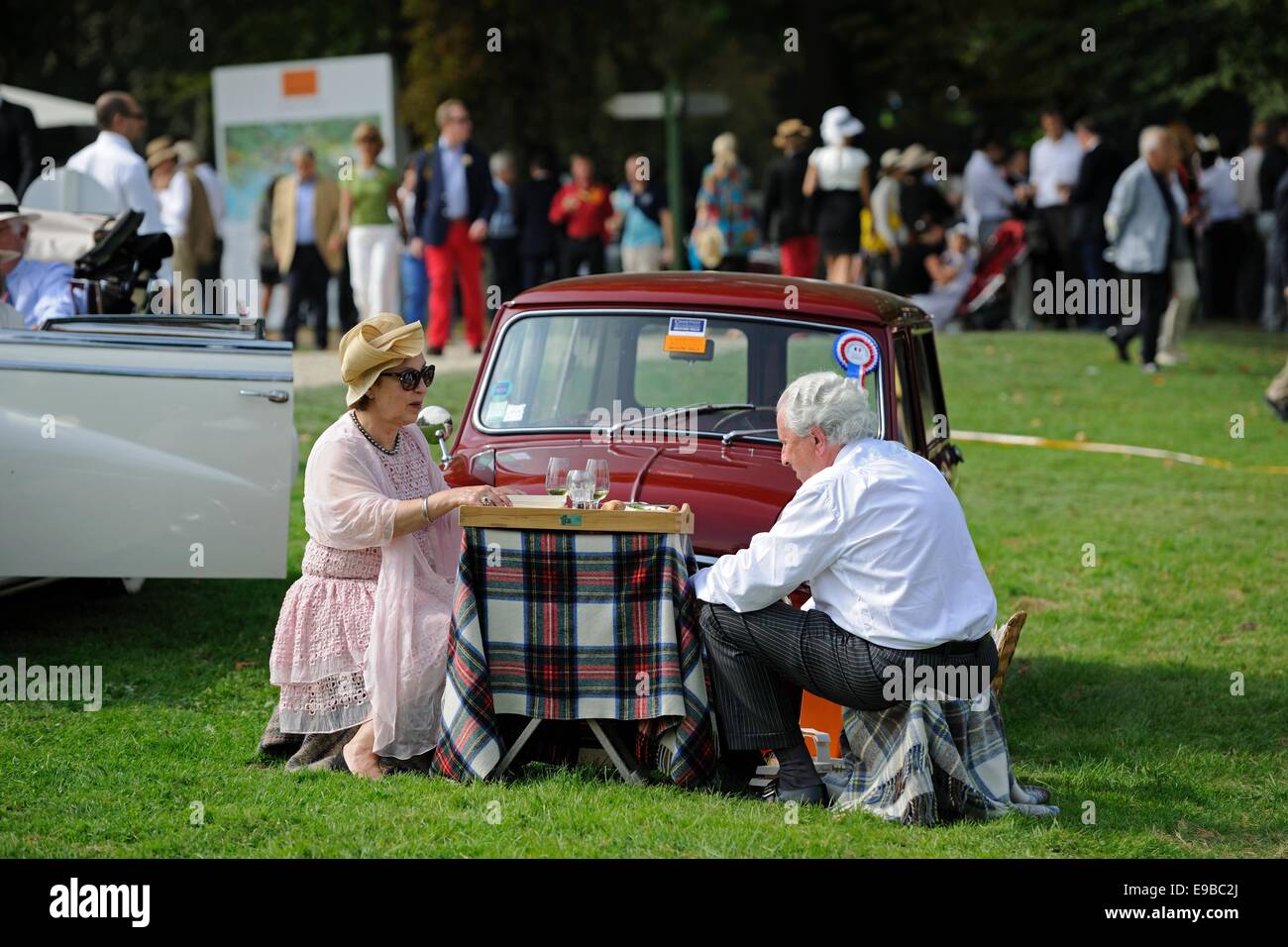 Älteres Ehepaar mit einem Picknick vor ihrer klassischen Mini bei einer Oldtimer-show Stockfoto