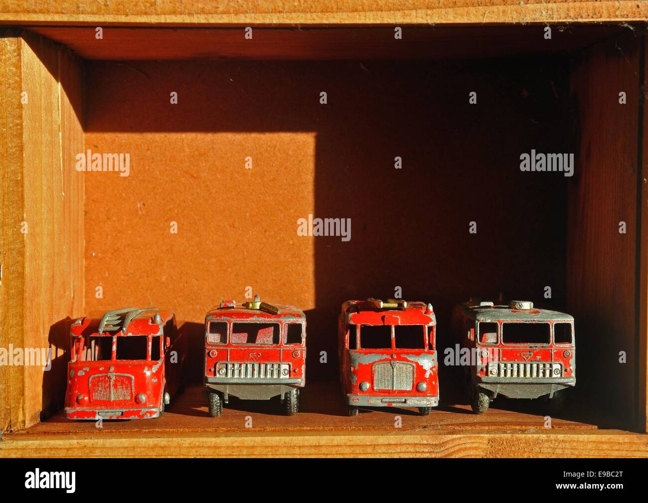 vier Matchbox Spielzeug Feuerwehrfahrzeuge in einer Holzkiste Stockfoto