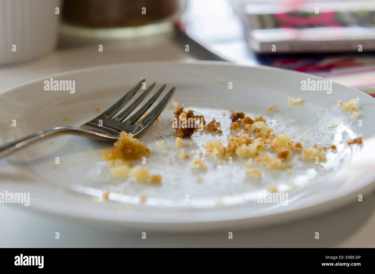 leere Teller mit Krümel mit Gabel auf einen Café-Tisch Stockfotografie