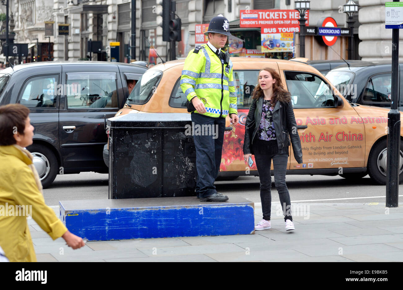 London, England, Vereinigtes Königreich. Metropolitan Polizei Offizier stehend auf ein blaues Feld am Piccadilly Circus Stockfoto