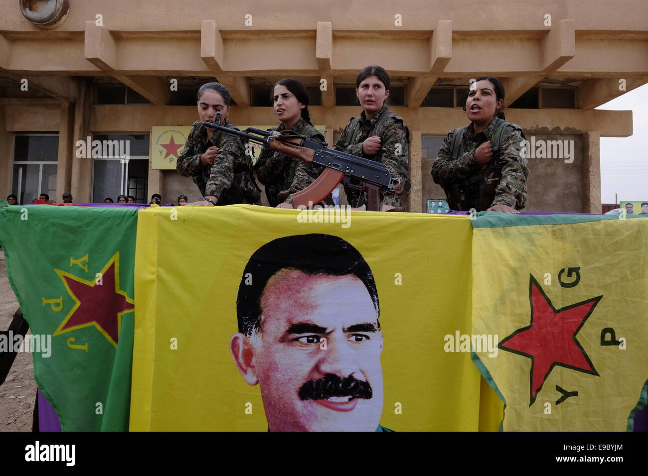 Kurdische Kämpfer der Frauenschutzeinheiten YPJ nehmen Teil In einem Vereidigung Prozess über einer Flagge mit der Figur Des ehemaligen militanten PKK-Führers Abdullah Ocalan in einer Ausbildung Camp in Al Hasaka oder Hassakeh Distrikt im Norden Syriens Stockfoto