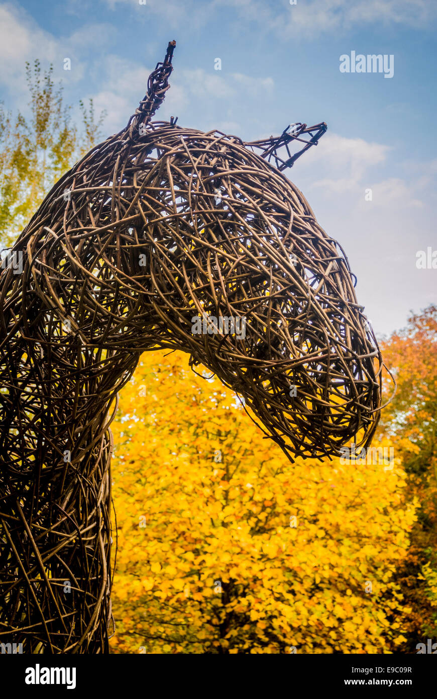 Willow-Skulptur eines Pferdekopfes mit herbstlichen Bäume im Hintergrund. Stockfoto