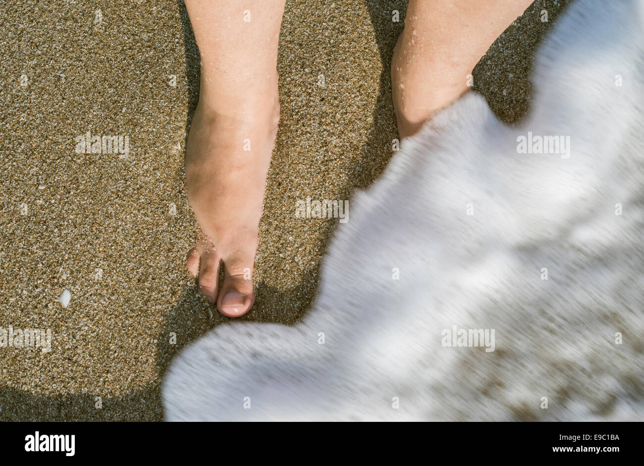 Zwei Beine in Wellen des Meeres. SUNY Tag Stockfoto