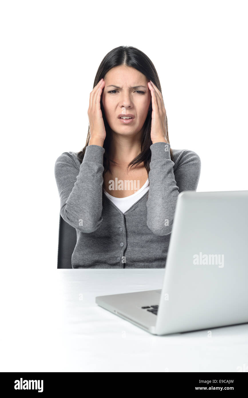 Junge Frau leidet unter Kopfschmerzen oder Migräne mit Blick auf Laptop auf dem Tisch. isoliert auf weißem Hintergrund Stockfoto