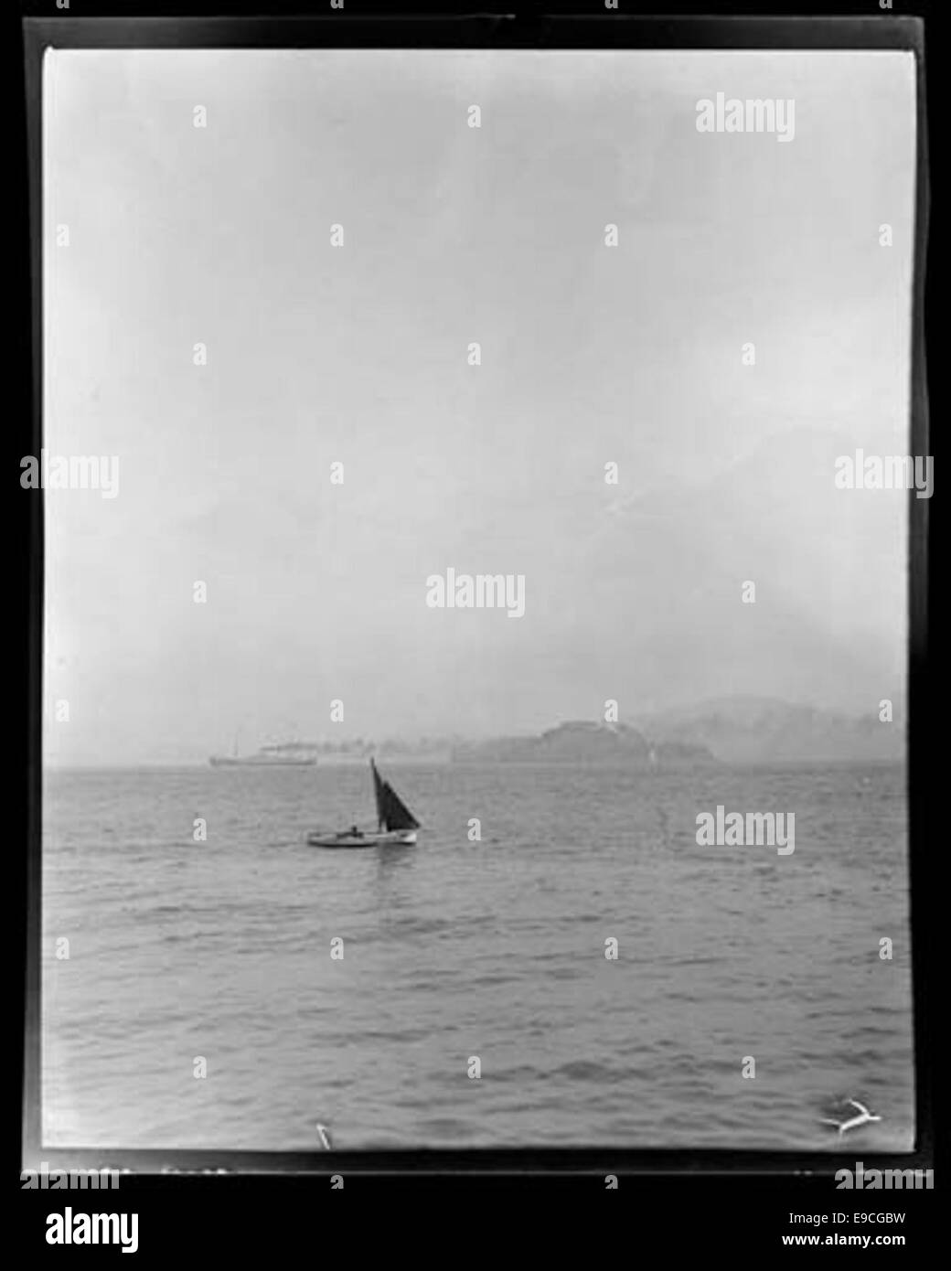 Ein Foto aus dem Spanisch-Amerikanischen Krieg, das Marineschiffe zeigt, die in der Bucht von San Francisco vor Anker liegen, mit einem Segelboot im Vordergrund. Das Bild spiegelt die Präsenz der Marine während des Krieges und die Bedeutung San Franciscos als strategischer Hafen wider. Stockfoto