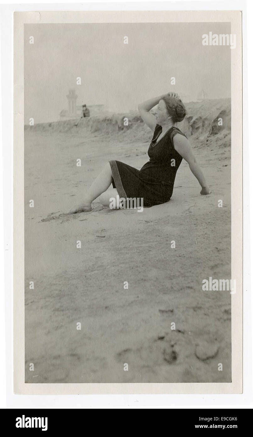 [Frau sitzt am Strand] Stockfoto