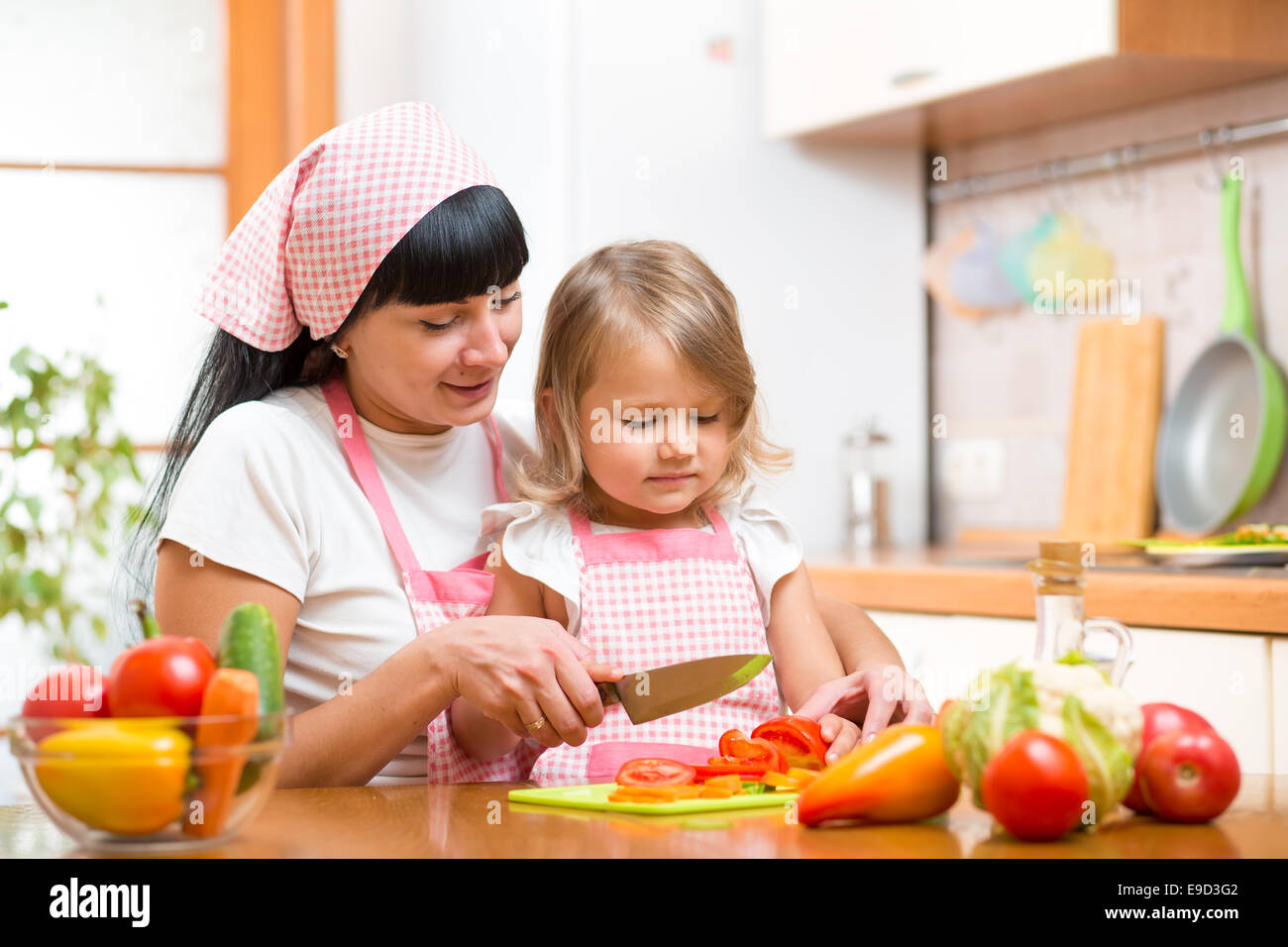 Mutter und Kind Mädchen Kochen und Schneiden von Gemüse in der Küche Stockfoto