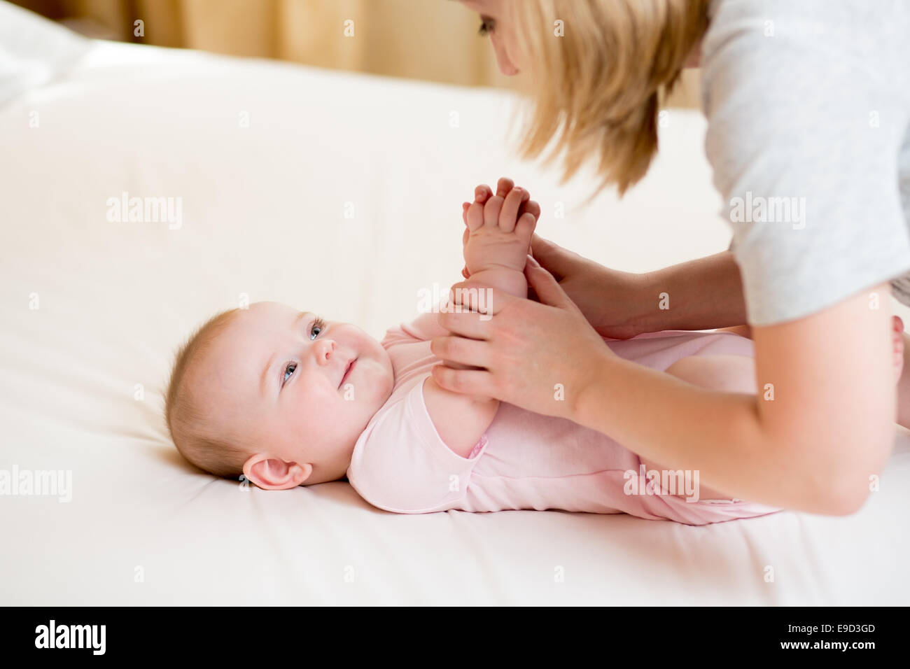 Mutter massieren oder machen Gymnastik Babymädchen Stockfoto