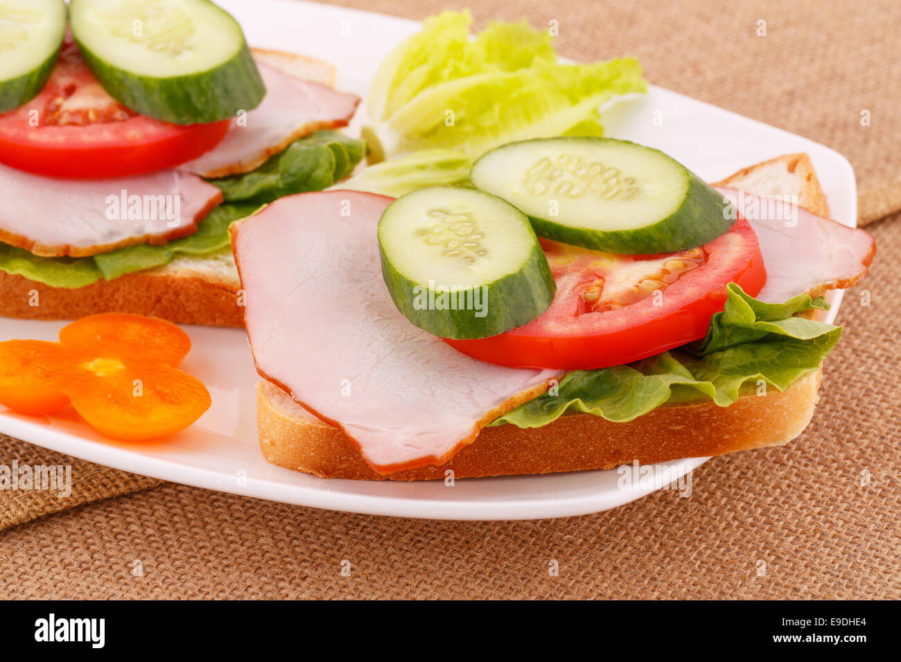 Sandwiches mit Zwieback, Gemüse, Speck auf Platte. Stockfoto