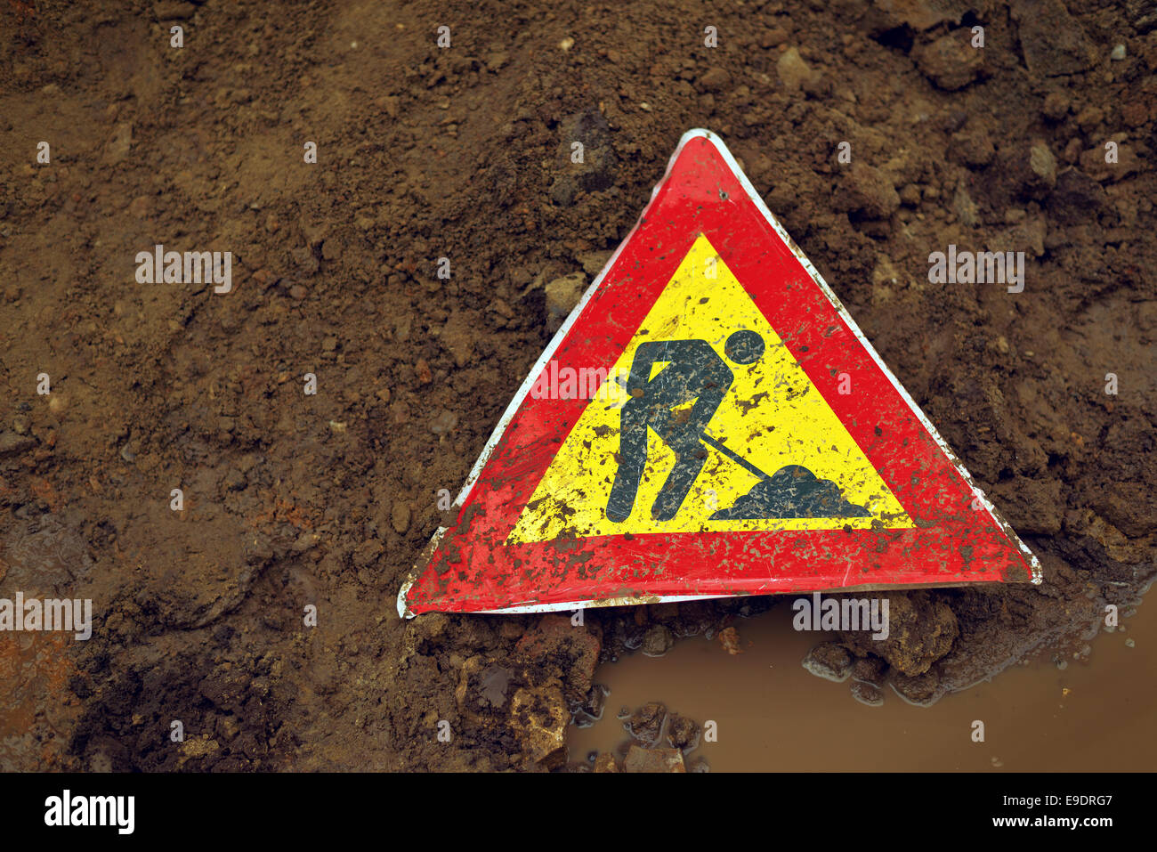 Mann auf Arbeit Straßenschild auf dem Boden Stockfoto