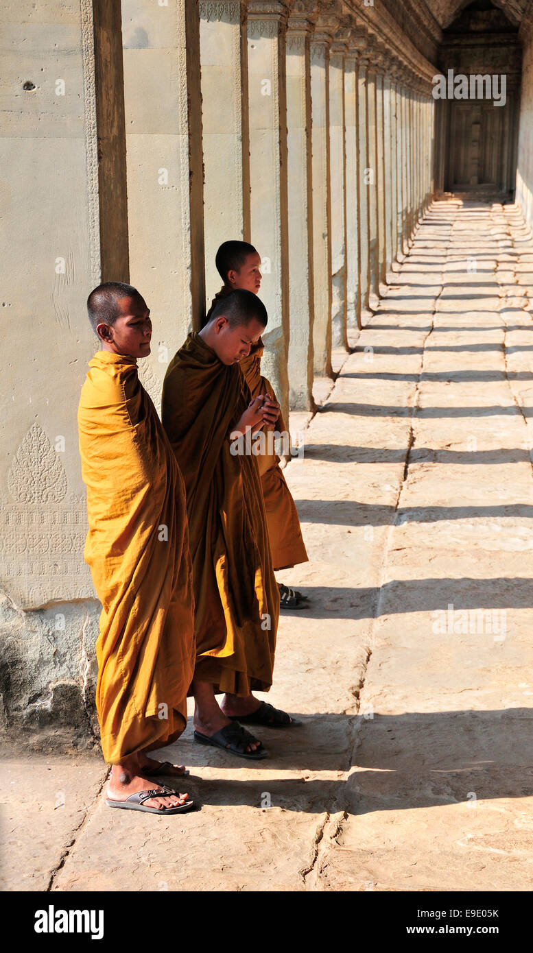 Mönche stehen entlang der Promenade am Eingang zu Angkor Wat, ein UNESCO-Weltkulturerbe in Siem Reap, Kambodscha, Südost-Asien Stockfoto