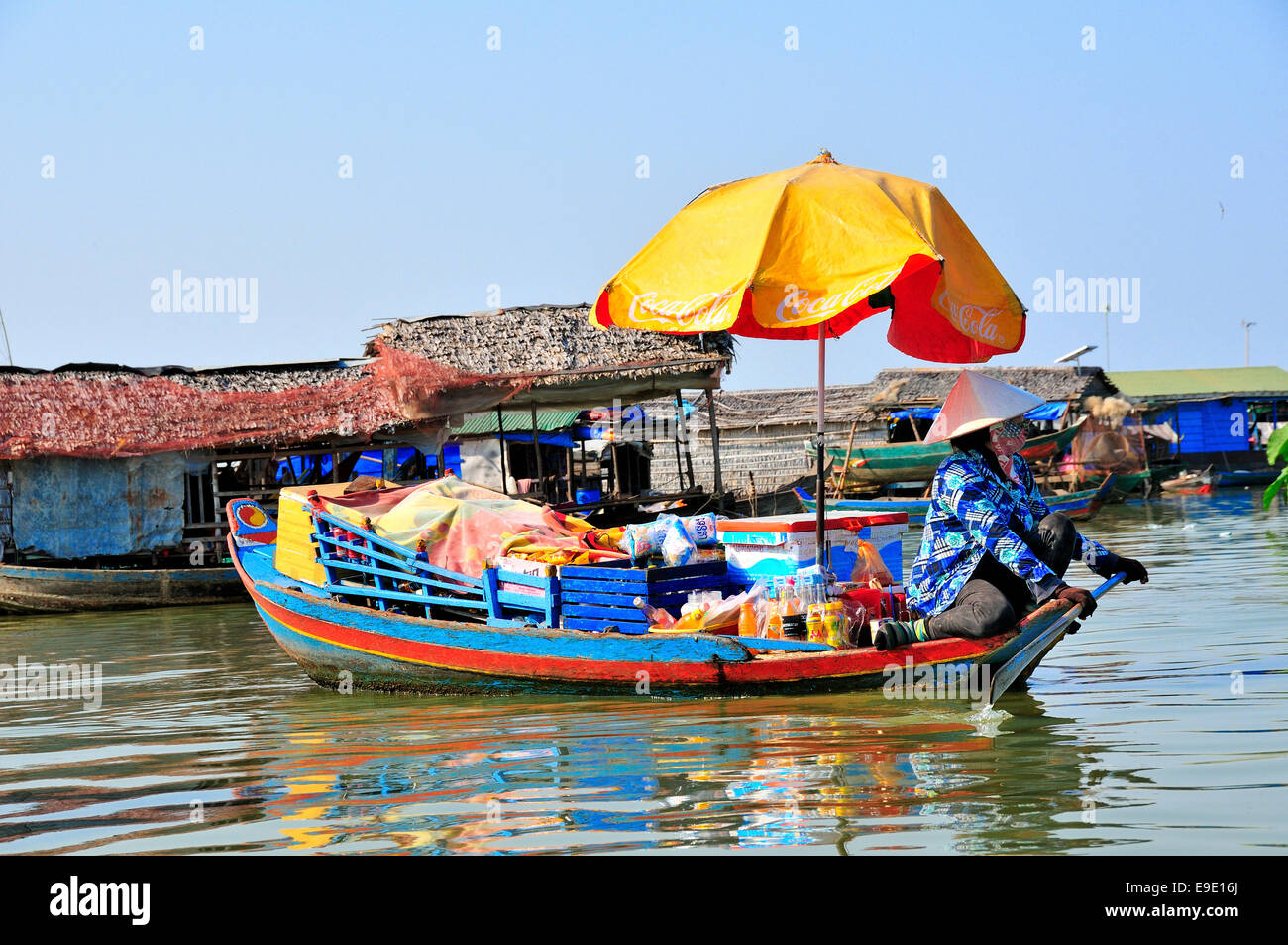 Frau Verkauf von Waren mit Sonnenschirm auf dem Boot auf See Tonle Sap, Kambodscha, Südostasien, Indochina Stockfoto