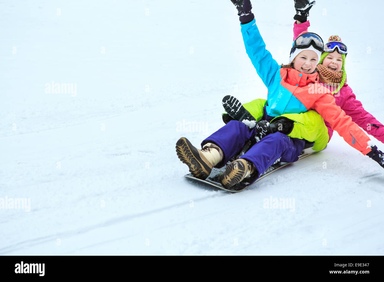 Mädchen im Teenageralter fahren Schlitten in den Alpen Stockfoto