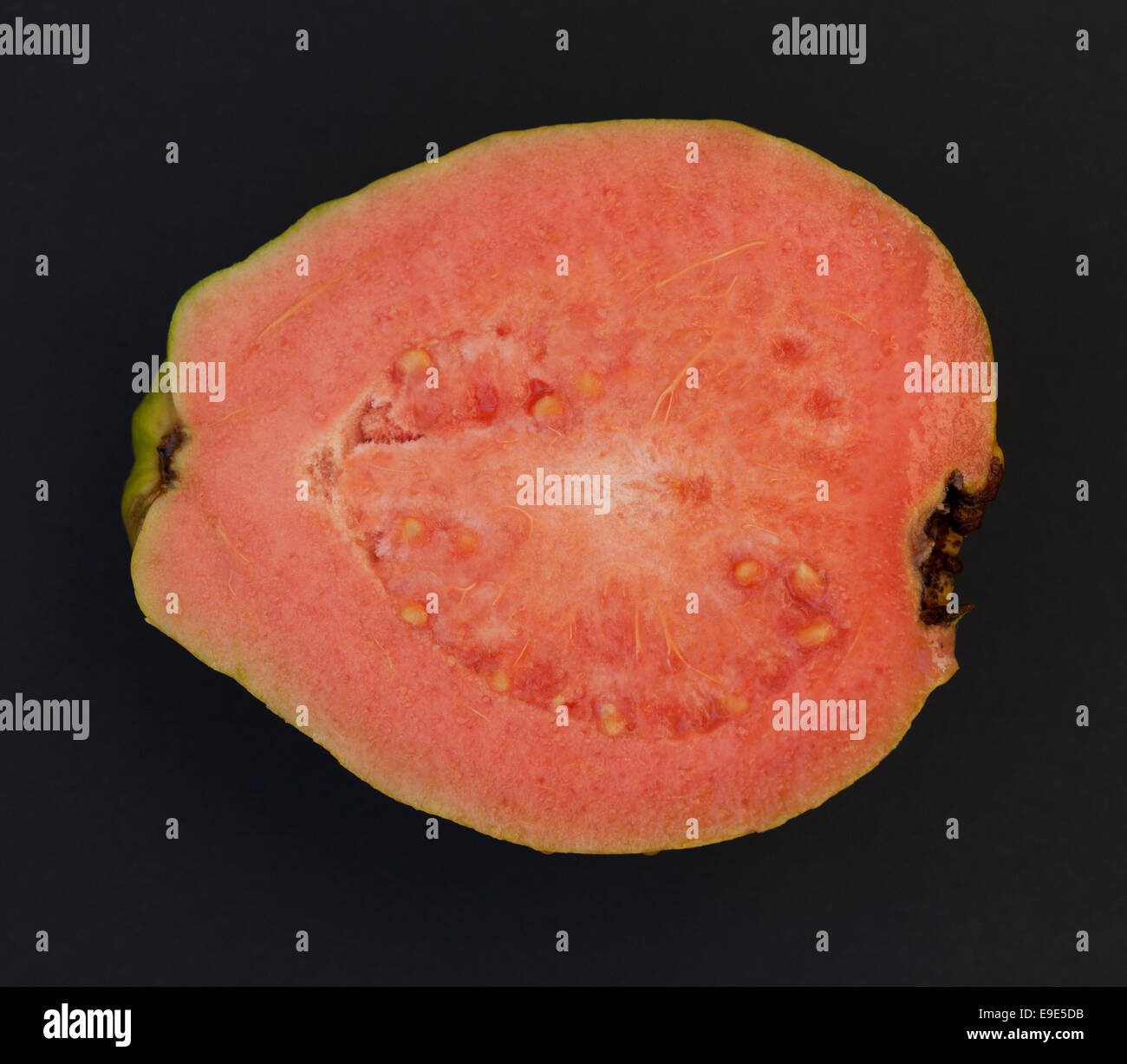 Eine Hälfte des Guavafrüchte auf schwarzem Hintergrund. Ansicht von oben Stockfoto