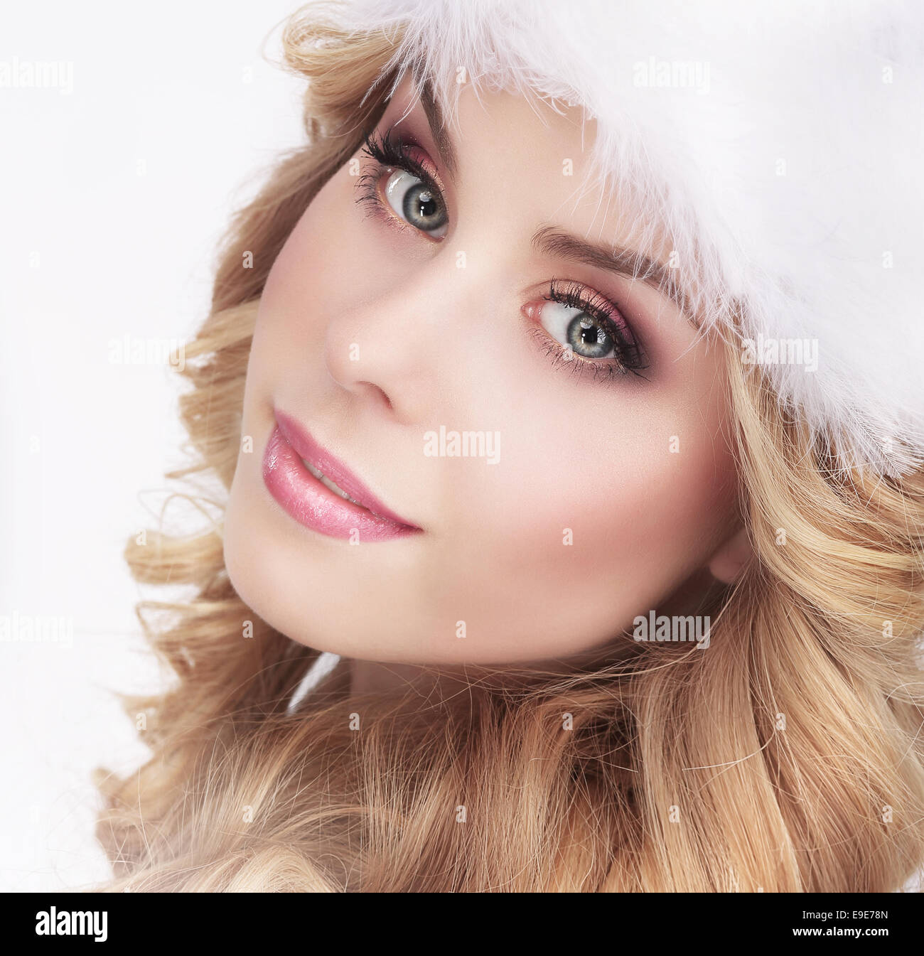 Süße junge Frau in pelzige weiße Kappe Stockfoto