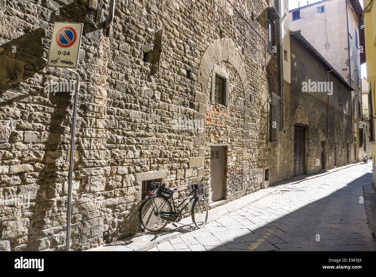 schmale Seitenstraße des schönen alten Steinmauer, deren Oberfläche & blockierte Up romanische Bögen erzählen eine Geschichte des Niedergangs, anzeigen Stockfoto
