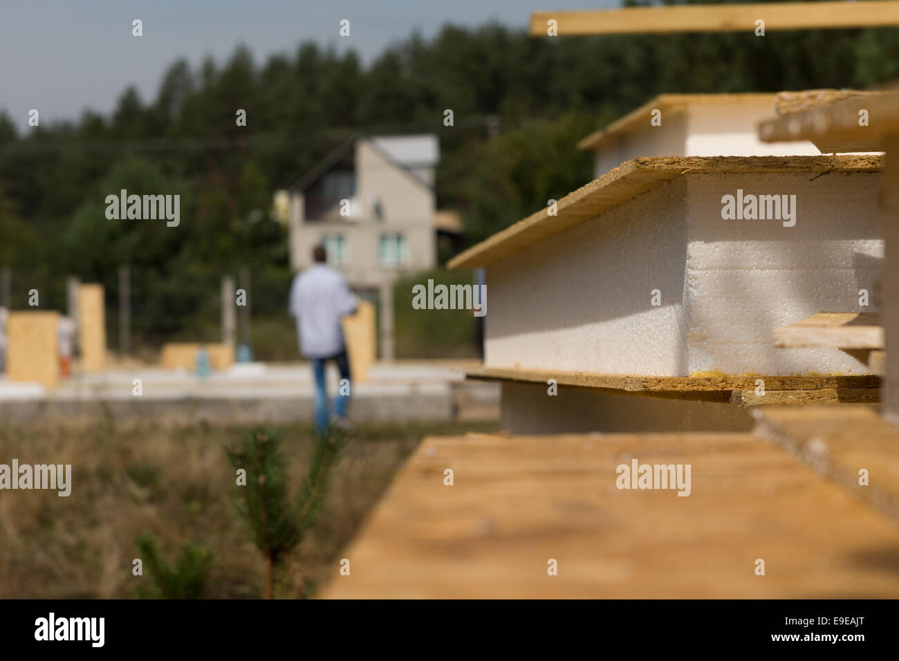 Nahaufnahme Detail eines isolierten Wand-Panels liegen auf einer Baustelle mit den Arbeitnehmern beschäftigt, die auf Kosten des Hauses in der backgr Stockfoto