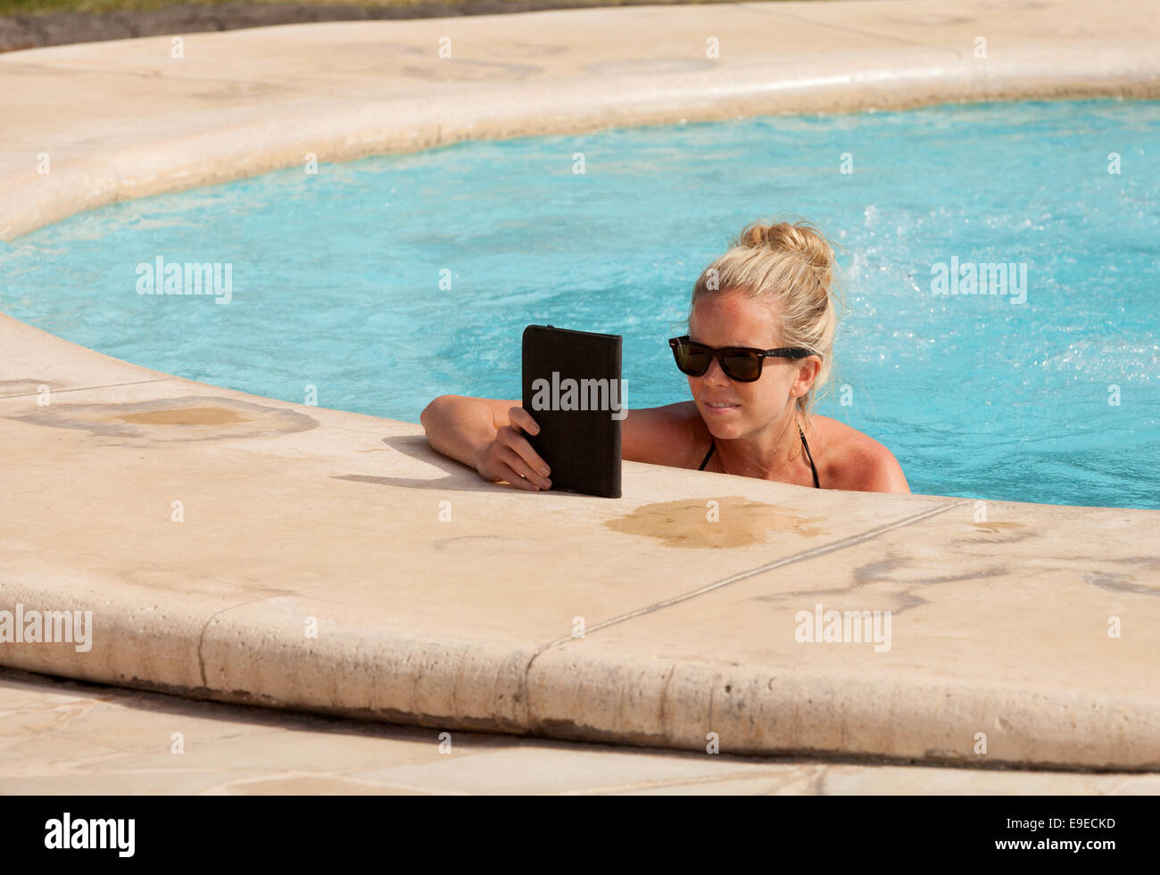 Frau liest einen Kindle in einem Schwimmbad im Urlaub, Mauritius Stockfoto