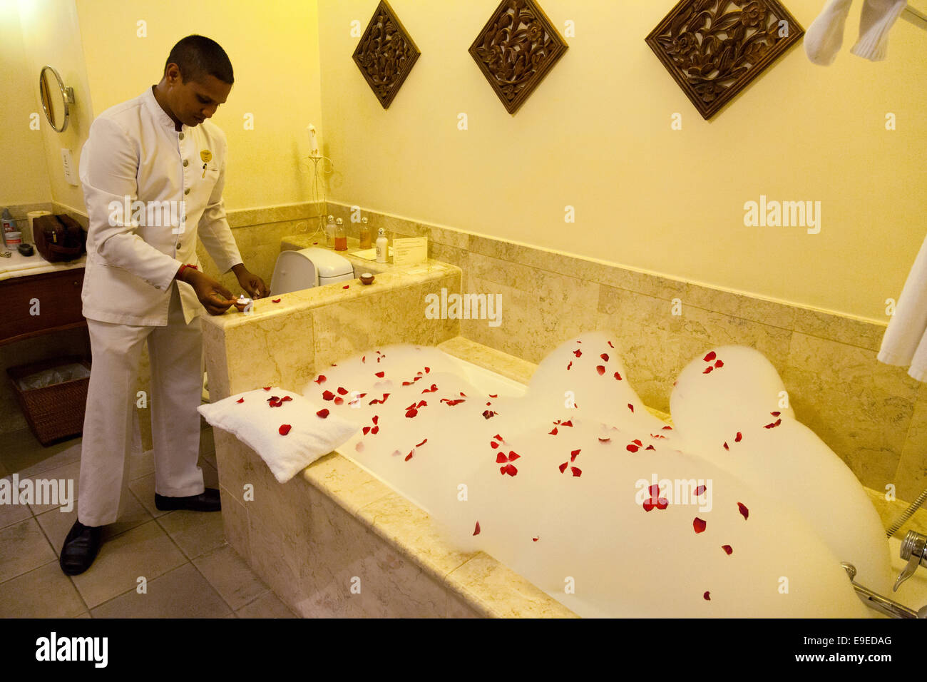 Ein Mitglied des Personals bereitet ein Rosenblütenbad für einen Client, der Luxus 5-Sterne-Residenz-Hotel, Belle Mare, Mauritius Stockfoto