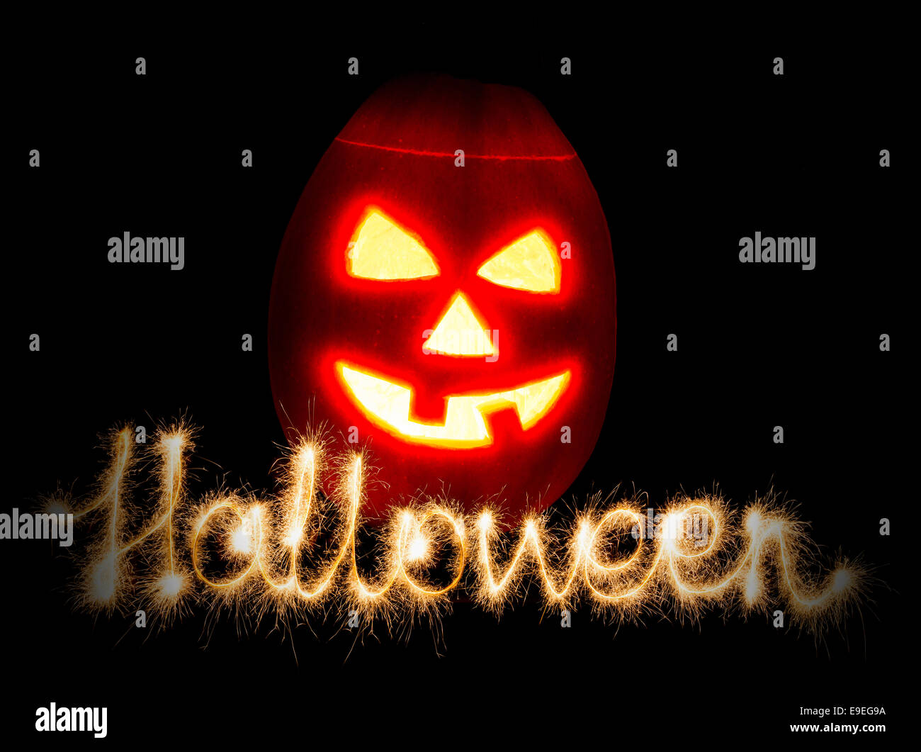 Halloween Kürbis Jack-o-Laterne Kerze angezündet und die Inschrift Halloween Wunderkerzen, auf schwarzem Hintergrund isoliert Stockfoto