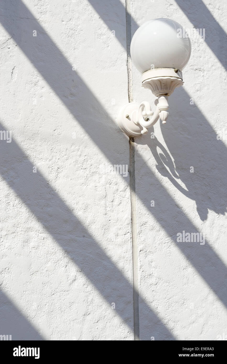 Traditionelle alte Straßenlaterne mit Schatten auf weiße Wand Stockfoto