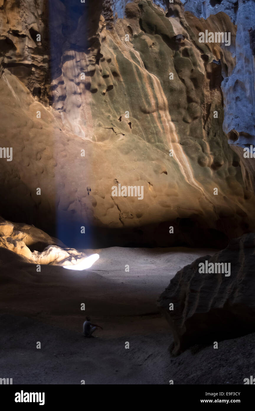 Ein Strahl des Tageslichtes in der Kathedrale cave Ankarana Nationalpark Madagaskar mit eine einsame Gestalt sitzen Stockfoto