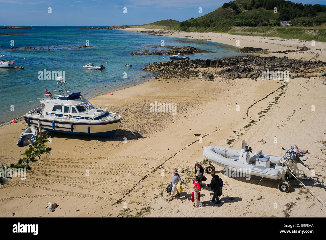 Touristen, die mit dem eigenen Boot auf Fishermans Beach Herm UK Stockfoto