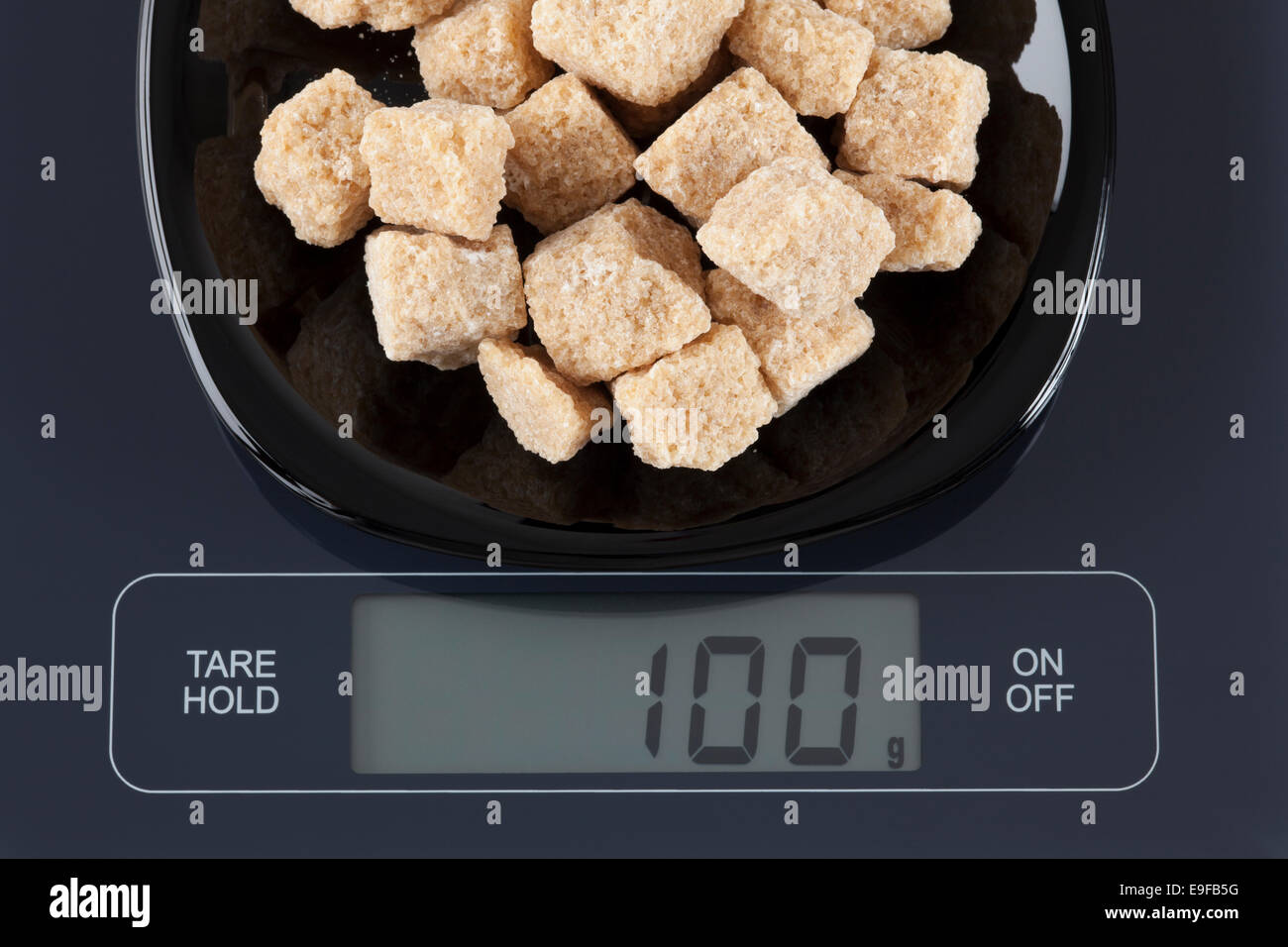 Braun Zuckerrohr Zucker in einer schwarzen Platte auf digitale Waage anzeigen 100 Gramm. Stockfoto