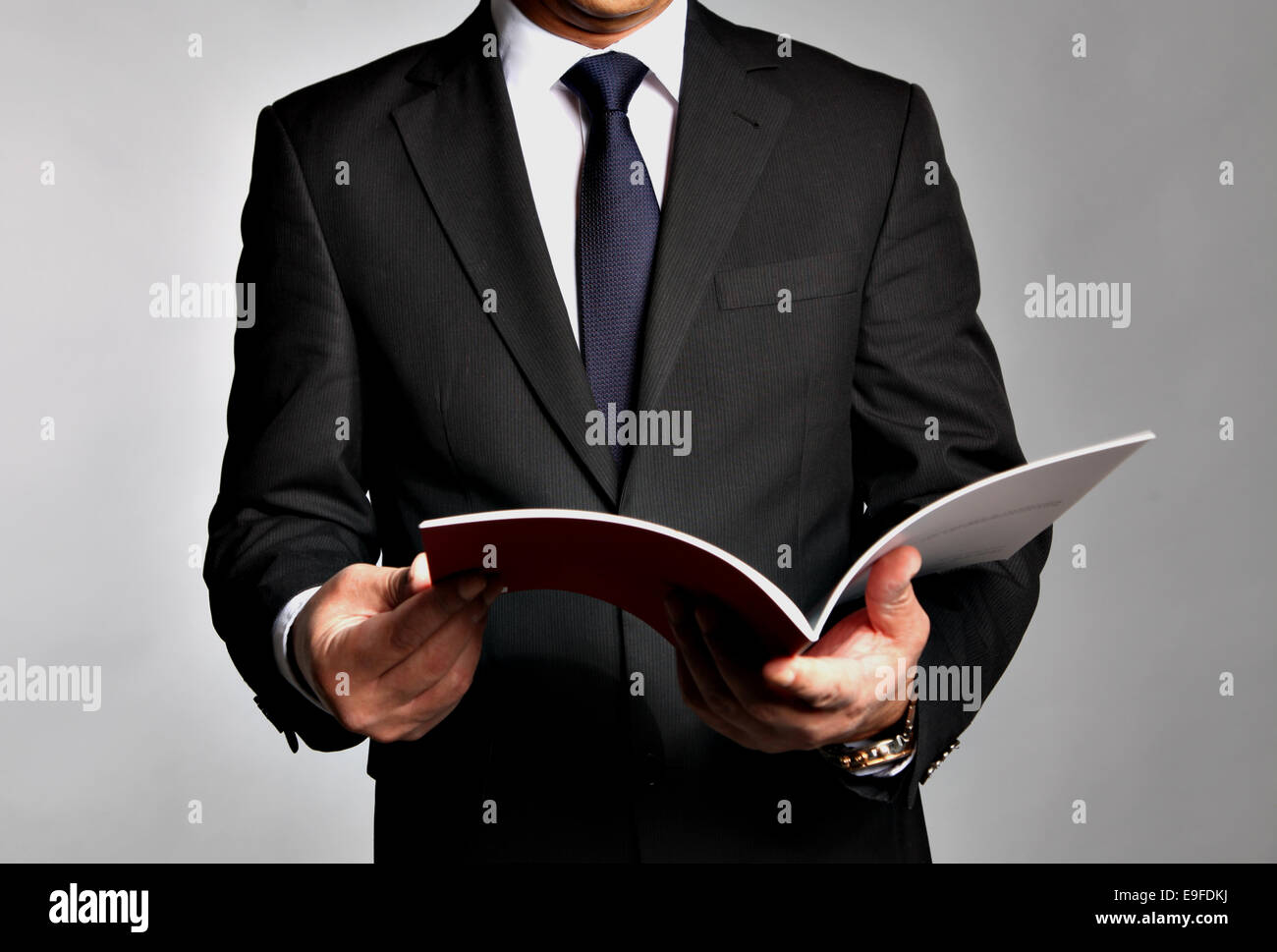 Geschäftsmann hält eine Broschüre Stockfoto