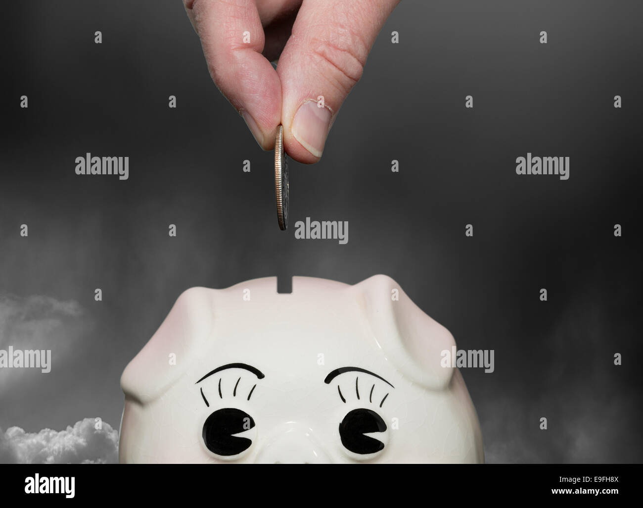 Sparen Geld im Sparschwein mit Fingern Stockfoto