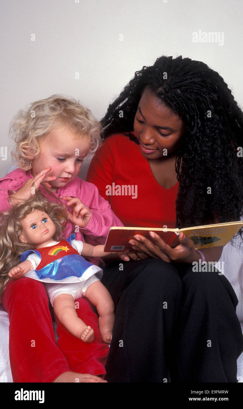 junge Frau liest, kleines Mädchen Stockfoto