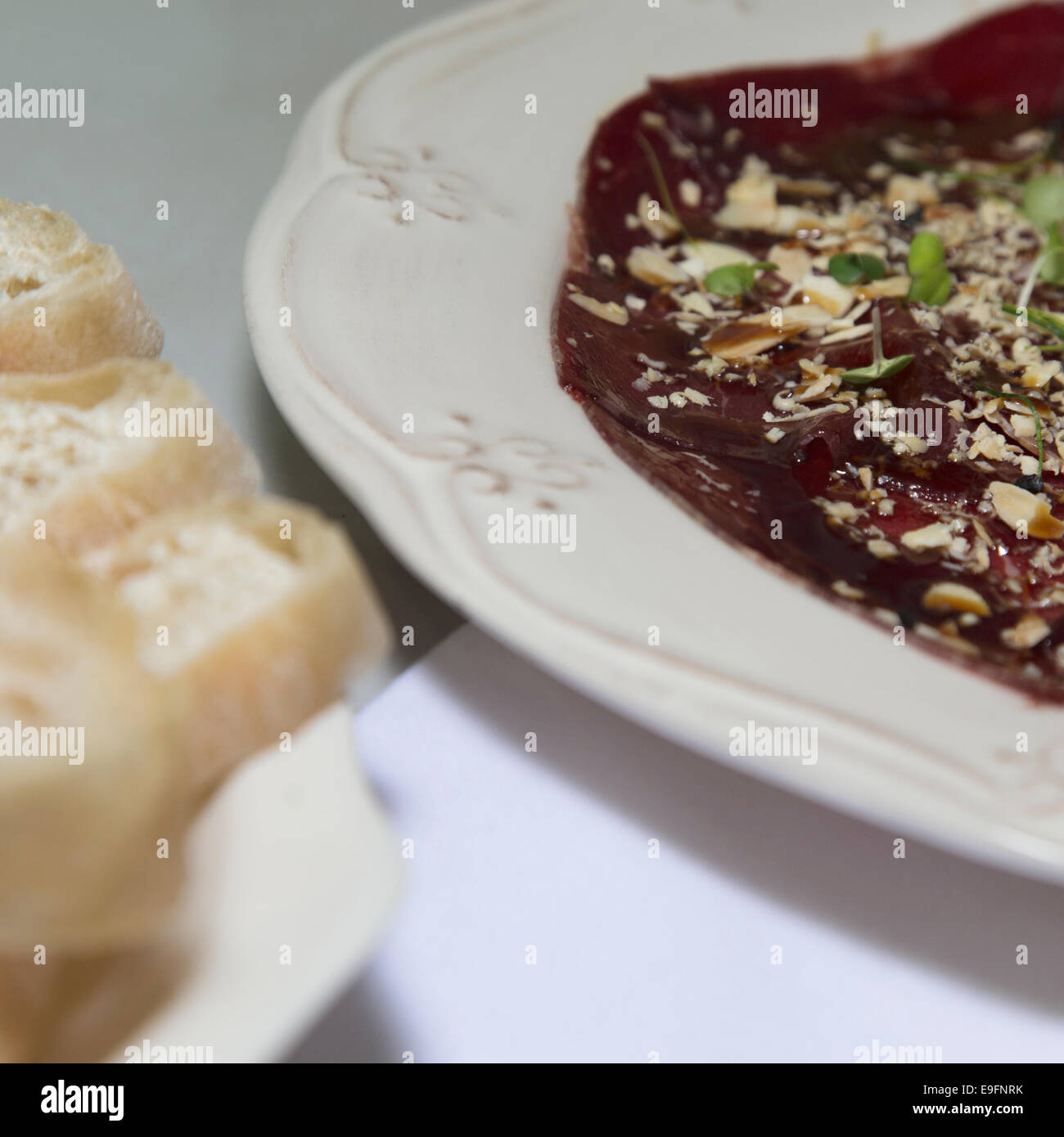 High-End-Essen, Cecina, Schinken, serviert mit gehackten Mandeln an der Spitze mit Perlen. Stockfoto