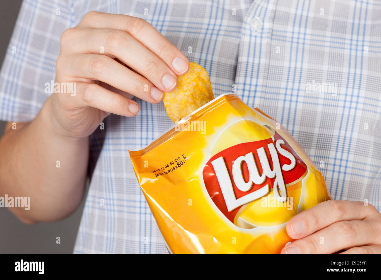 Tambow, Russische Föderation - 20. Januar 2013 Hand nimmt, Kartoffel-Chips von Lay-Tasche. Es ist eine Kartoffel-Chips mit Käse. Stockfoto